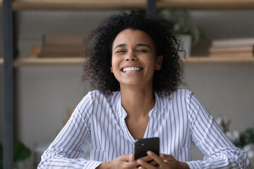Overjoyed millennial African American woman feel euphoric reading good promotion news on...