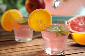 Delicious refreshing drink with orange and mint on wooden table