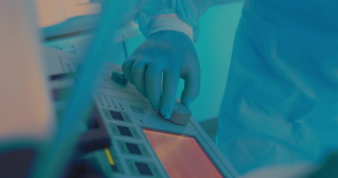 Close-up a medical hand in disposable gloves is spinning and pushing a button on the anesthesia workstation.