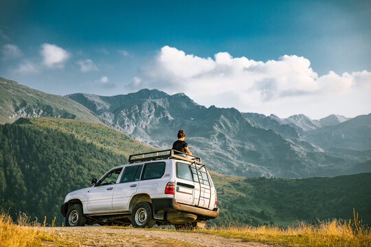 Person on top of 4x4 vehicle in the mountains of the Nationalpark Sharr, Brezovicë, Kosovo