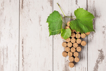 Creative grape bunch made of corks on wooden background top view. Wine concept.