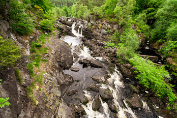 The Rogie Falls, a series of waterfalls near the village of Contin, Ross-Shire, Scotland, UK, viewed here from the suspension bridge. - 448389591