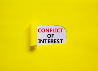Conflict of interest symbol. Words 'Conflict of interest' appearing behind torn yellow paper. Beautiful yellow background. Business, conflict of interest concept, copy space.