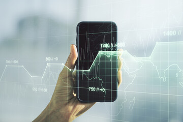Multi exposure of abstract statistics data hologram interface and hand with cellphone on background, computing and analytics concept