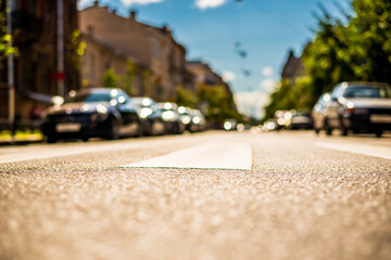 Clear day in the big city, city street with cars between old houses. View from the pedestrian crossing