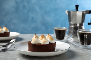 Delicious salted caramel chocolate tart with meringue served on light grey marble table
