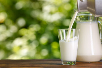 milk pouring from metal can into glass outdoors