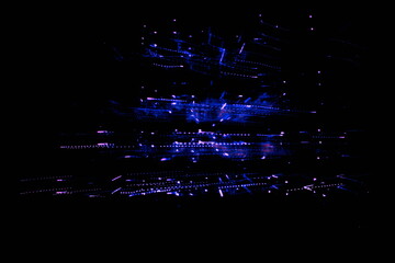 Abstract light trails from dozens of small point lights in hues of violet and blue.