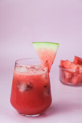 Summer ice watermelon cocktail. Organic soft drink cold snacks on pastel pink wooden background with copy space.
