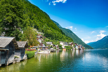 Obraz premium Scenic view of famous Hallstatt lakeside town reflecting in Hallstattersee lake in the Austrian Alps on a sunny day in summer, Salzkammergut region, Austria