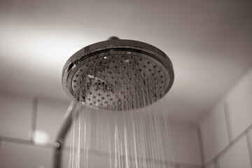 Close-up of water streaming from rain shower head in bathroom. Modern rain shower head. 