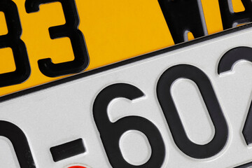 One white and one yellow vehicle registration plates