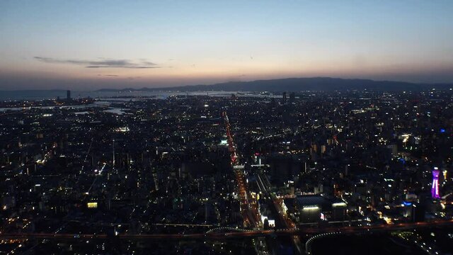 OSAKA, JAPAN : Aerial high angle sunrise view of CITYSCAPE of OSAKA. View of buildings and street traffic around Osaka bay and Kobe port. Long time lapse wide view shot, night to morning.