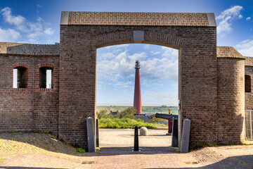 Blick durch das Eingangstor von Fort Kijkduin, genannt Fort Morand, zum Leuchtturm Huisduinen, genannt der lange Jaap, Den Helder, Niederlande, NordHolland
