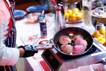 oysters in a frying pan cooks the chef, fire