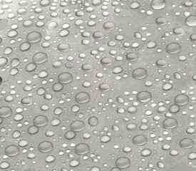  grey drops of water on a smooth plane surface