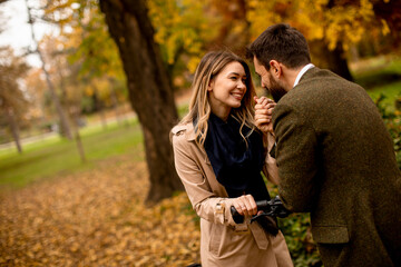 Young couple in the autumn park with electrical bicycle