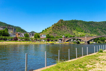 Fototapeta premium Cochem, Germany, June 13, 2021. Beautiful view of the colorful buildings along the river with a bridge and the old town of Cochem on the Moselle river in Rhineland-Palatinate, Germany.
