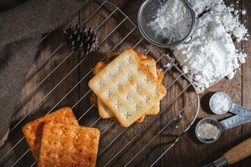 square dry crackers biscuit on a wooden table. wooden texture dark