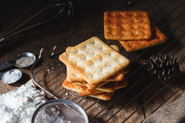 square dry crackers biscuit on a wooden table. wooden texture dark