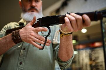 Male hunter reloads rifle in gun store