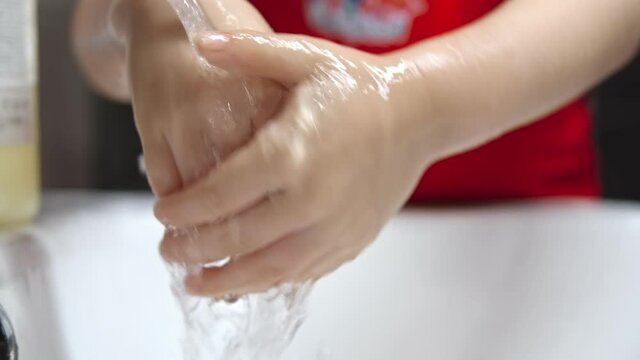 Little girl washing her hands with a hand wash gel in sink. Clean hand concept. Coronavirus protection.
