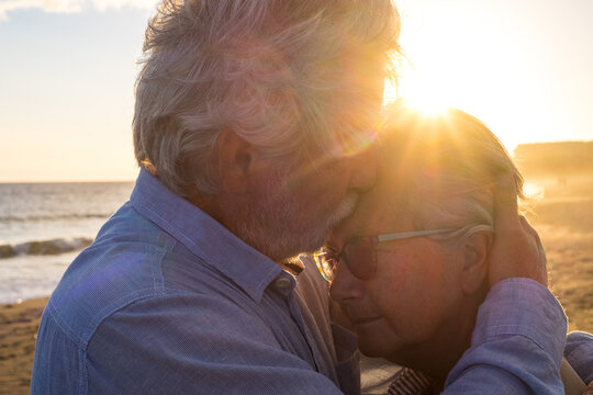 Portrait Of Couple Of Two Happy Seniors And Mature And Old People At The Beach Together. Pensioner And Retired Man Consoling Sad Depressed Wife Crying..