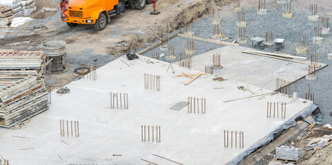 concreting work: construction site worker during concrete pouring into formwork at building area...