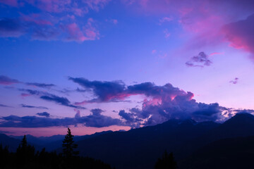 Dramatic sky at sunrise or sunset. Beautiful colorful clouds with silhouette of mountain.