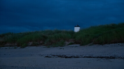 Seaside tower behind beach by nightfall