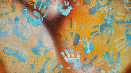 Fototapeta na wymiar Handprints and dripping paint on the textured background of an old painted wall.