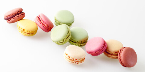 French sweet colorful cookies macarons macaroons flying on light neutral background.