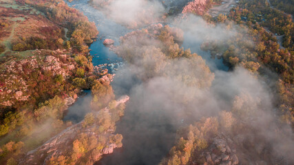 Obraz na płótnie Canvas amazing aerial view of foggy morning river and colorful trees. drone shot