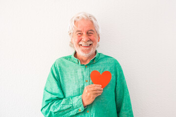 portrait of one mature man smiling and looking at the camera with a red heart on his chest - man...