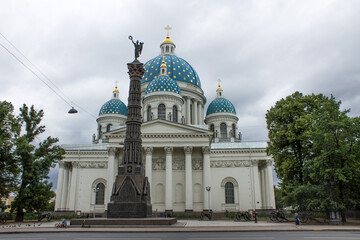 Saint Petersburg, Russia, July, 20, 2021: Izmailovsky Cathedral of the Holy Life-giving Trinity with blue domes against a cloudy sky and green trees on a summer day