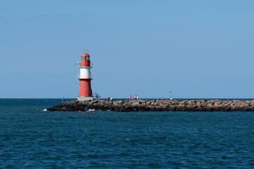 Red and white lighthouse on the Baltic Sea (inland sea) with cloudless sky and bright sunshine