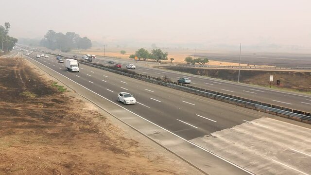  Traffic on northern califonia freeway during fire season with thick smoke in air.