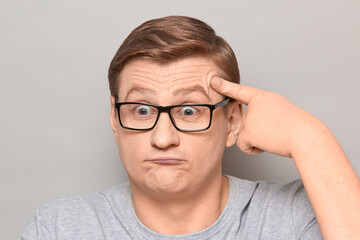 Fototapeta premium Portrait of thoughtful funny mature man touching temple with finger