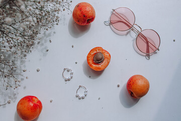 жемчужные серьги,розовые очки, персики абрикосы и цветы на белом фоне