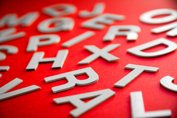 Mixed letters pile close up view photo. Red background