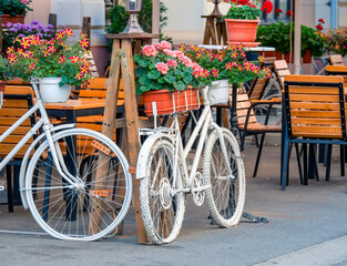Fototapeta na wymiar Vintage ornament decorative bicycles painted in white at an outdoor terrace cafe restaurant, in the center of Timisoara, Romania