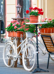 Fototapeta na wymiar Vintage ornament decorative bicycles painted in white at an outdoor terrace cafe restaurant, in the center of Timisoara, Romania