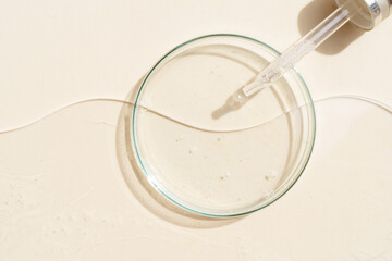 Glass petri dish with transparent pure serum for skin care