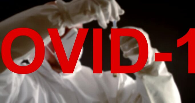 red words COVID-19 against the background of a bald, serious man in overalls, gloves, a protective mask on face and a test tube in hands. the label is moving