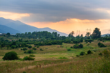 Fototapeta premium Warm sunset landscape with field and mountains 