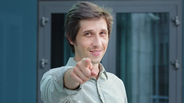 We want you in our team. Closeup of millennial professional businessman hr employer standing outdoors in middle of day pointing finger at camera choosing spectator to join staff posing challenge