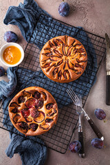 rustic plum cake on dark background , top view