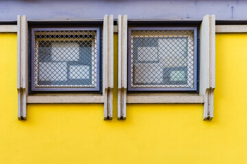 Fototapeta na wymiar Wall of a yellow building with two square sales