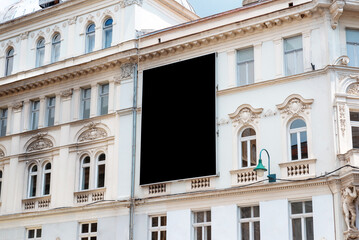 Empty black billboard surface for mockup on old city building facade