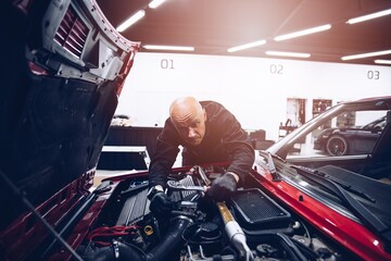 Man repairing car engine with his tools. Car service